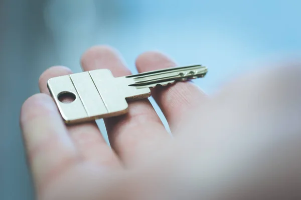 Moving into a new home: Close up of a hand holding a key. Proper