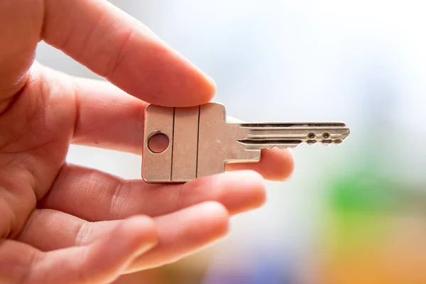 Προχωρώντας σε ένα νέο σπίτι: Κλείστε ένα χέρι κρατώντας ένα κλειδί. Κατάλληλη — Φωτογραφία Αρχείου