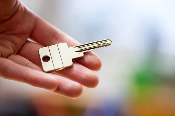 Moving into a new home: Close up of a hand holding a key. Proper Stock Image