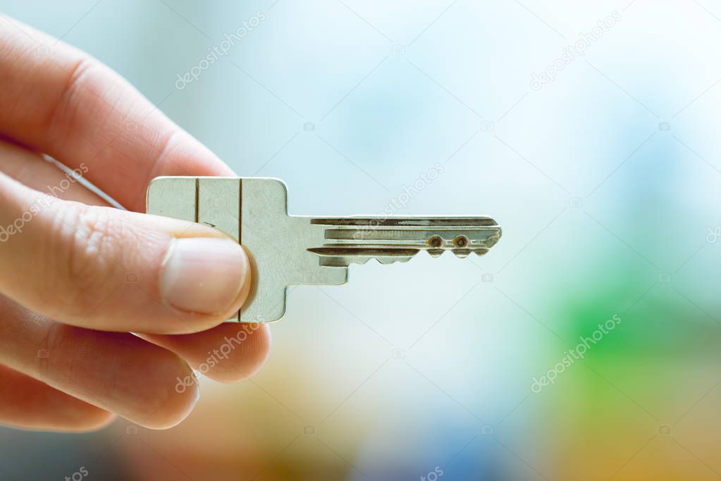 Moving into a new home: Close up of a hand holding a key. Proper