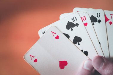 İskambil kartları: bir adamın elinde poker kartları