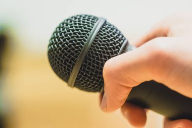 Röportaj: gazeteci elinde bir mikrofon tutuyor. Yakın