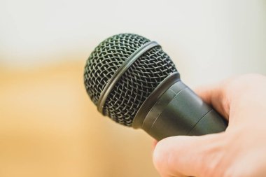 Röportaj: gazeteci elinde bir mikrofon tutuyor. Yakın