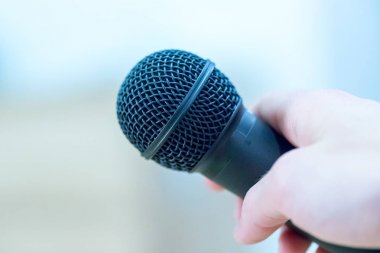 Röportaj: gazeteci elinde bir mikrofon tutuyor. Yakın