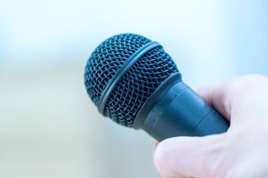 Röportaj: gazeteci elinde bir mikrofon tutuyor. Yakın