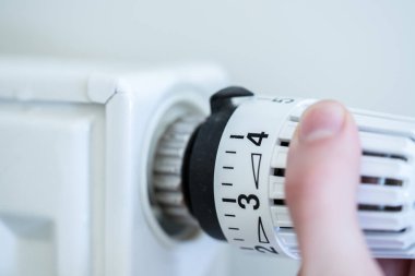 Isıtıcı üzerinde ısı regülatörü, resmi yakın. Isıtma maliyetleri. 