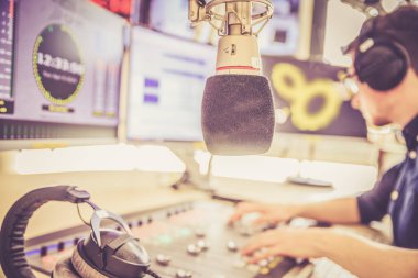 Radyo moderatör modern bir yayın stüdyosunda oturuyor ve t