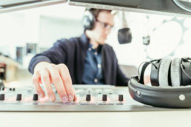 Radyo moderatör modern bir yayın stüdyosunda oturuyor ve t