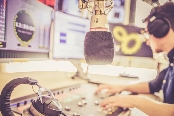 Moderador de radio está sentado en un estudio de radiodifusión moderna y t — Foto de Stock