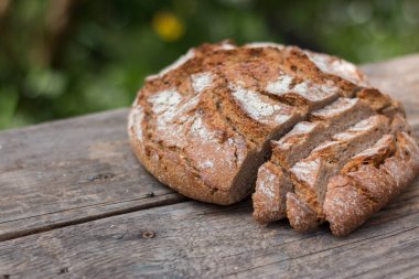 Rustik ahşap kesme tahtası üzerinde dilimler halinde taze ekmek ve bıçak, 