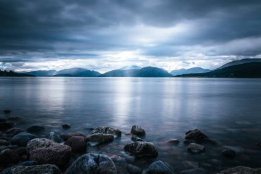 İskoçya'da mistik manzara göl sahne: Bulutlu gökyüzü, güneş ışınları 