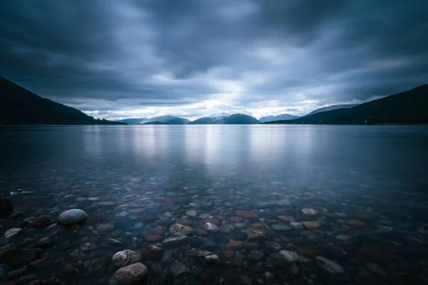 Мистический пейзаж озера в Шотландии: облачное небо, солнечные лучи — стоковое фото