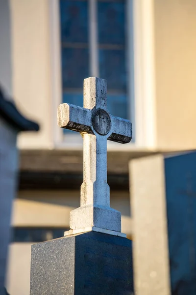 Kamenný kříž na hřbitově, večerní slunce — Stock fotografie