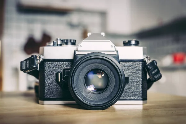 Retro vintage photography camera on a wooden table, blurry backg — Stock Photo, Image