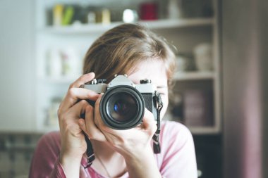 Genç kız antika bir fotoğraf makinesiyle fotoğraf çekiyor, retro styl.