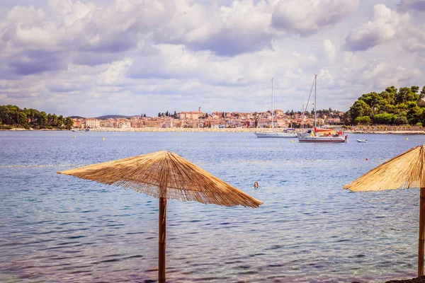 Genieten van de vakantie: zonnescherm en helder water, strand, Kroatië — Stockfoto