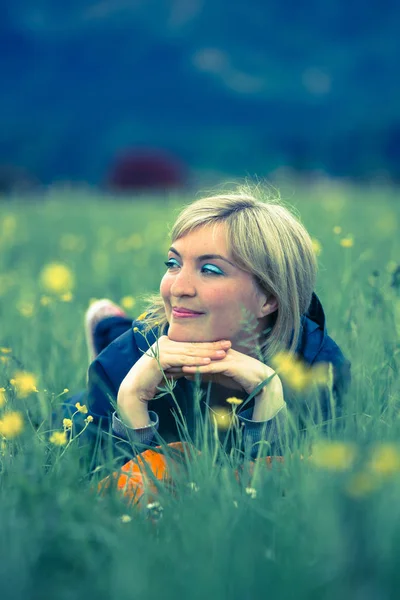 Dromerige zomer namiddag: meisje ligt in het groene gras — Stockfoto