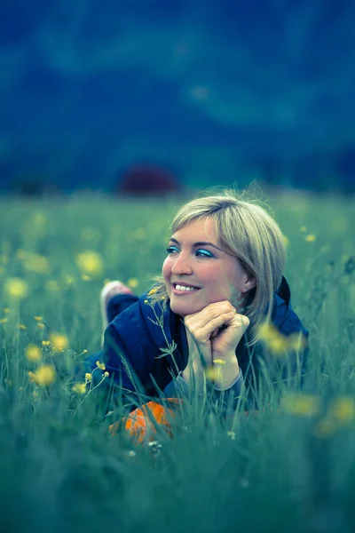 Dromerige zomer namiddag: meisje ligt in het groene gras — Stockfoto