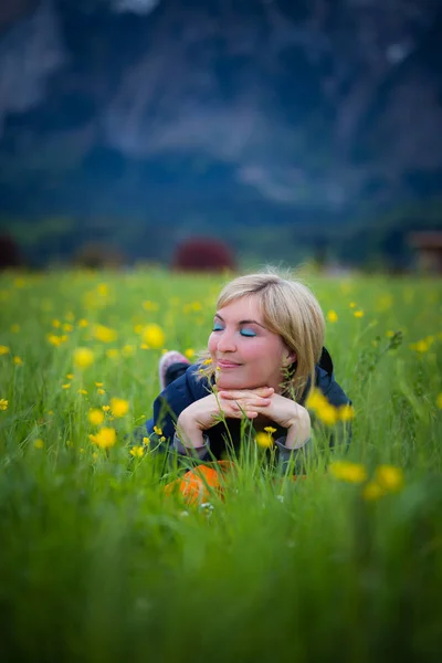 Dromerige zomer namiddag: meisje ligt in het groene gras — Stockfoto