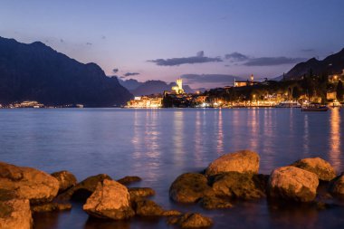 Evening scene at lago di garda: Lake, rocks and village clipart