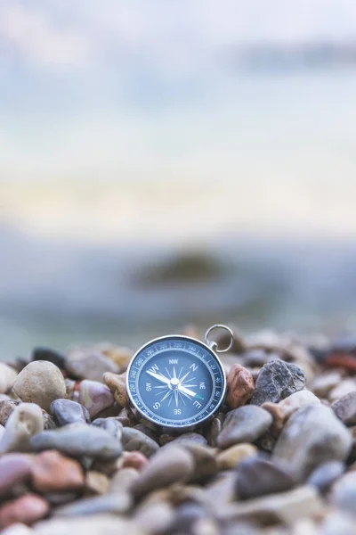 Navigation concept: Compass is lying on the beach near the sea — Stock Photo, Image