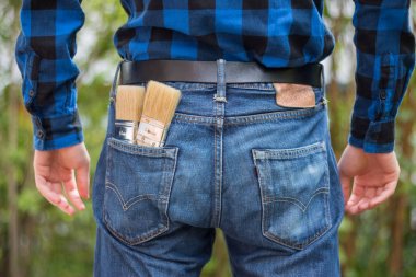 Ev tamircisi: Merhaba boya fırçaları ile genç bir adamın arka görünümü