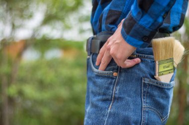 Ev tamircisi: Merhaba boya fırçaları ile genç bir adamın arka görünümü