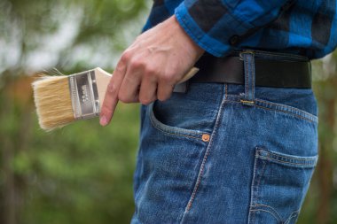 Ev tamircisi: Merhaba boya fırçaları ile genç bir adamın arka görünümü