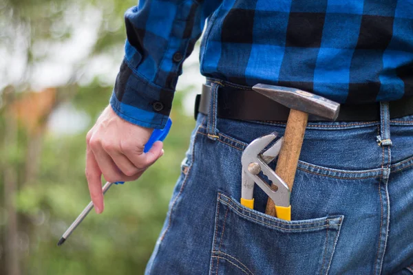 Ev tamircisi: Çekiç, kalem ve genç bir adamın arka görünümü 