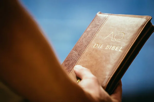 Christian preacher: Young man is holding the bible, praying — Stock Photo, Image