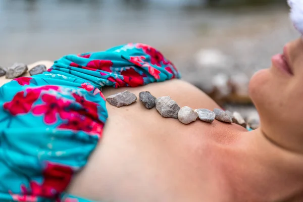 Kiezelstenen op het lichaam van een jonge aantrekkelijke vrouw, Wellness — Stockfoto