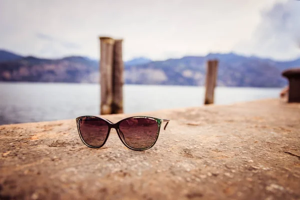 Destino de vacaciones: Gafas de sol en el suelo, borrosa italiana vi — Foto de Stock