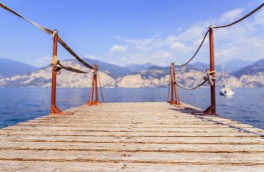 Yaz tatili: Mavi göl suyu üzerinde ahşap rıhtım iskelesi, metin aralığı