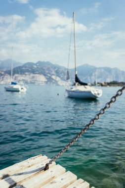 Yelken: Ahşap rıhtım iskelesi, arka planda yelkenli tekneler.