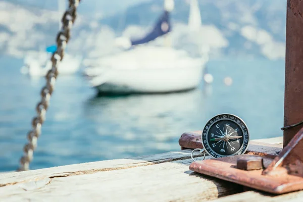 Sailing: nautical compass on wooden dock pier. Sailing boats in — Stock Photo, Image