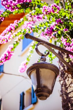 Pastoral bir İtalyan köyünde çiçeklerle sokak lambası