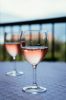 Verandada bir kadeh gül şarabının tadını çıkarmak, yaz tatilinde 