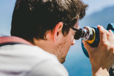 Kafkas adam merakla dürbünle bakıyor. 