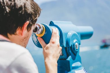 Kafkas adam merakla dürbünle bakıyor. 