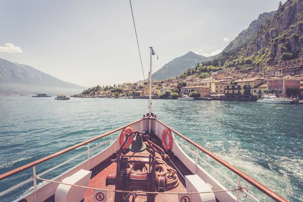 Boat tour: Boat bow, view over azure blue water, village and  mo