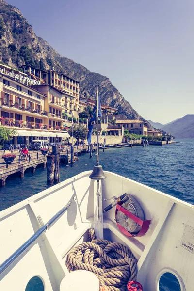 Boat tour: Boat bow, view over azure blue water, village and  mo