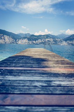 Mavi göl suyu üzerinde uzanan ahşap rıhtım iskelesi, la dağlar