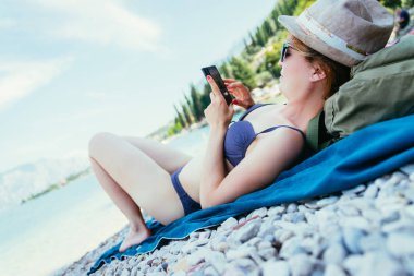 Sahilde Smartphone: hasır şapka ile güzel genç kız 