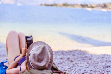 Sahilde Smartphone: hasır şapka ile güzel genç kız 