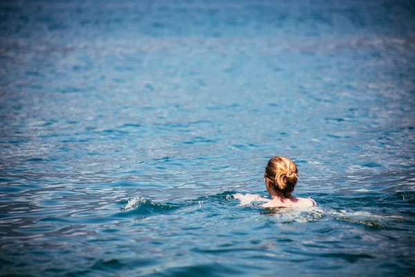 La mujer está nadando en el agua cristalina, lago di garda — Foto de Stock