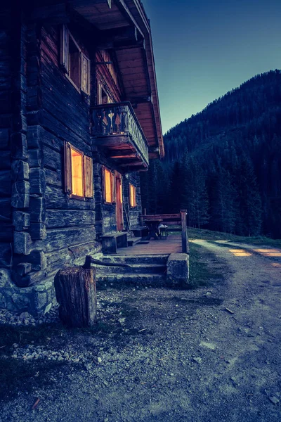 Svátek v Alpách: rustikální dřevěná bouda v noci. — Stock fotografie