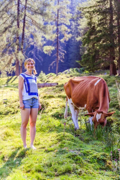 Vakantie op de boerderij: jonge vrouw is het aanraken van een koe in een idyllische Natur — Stockfoto