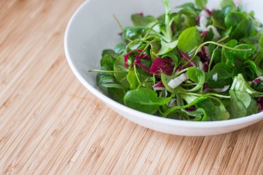 Ahşap bir ta bir seramik kase diyet için vejetaryen yeşil salata