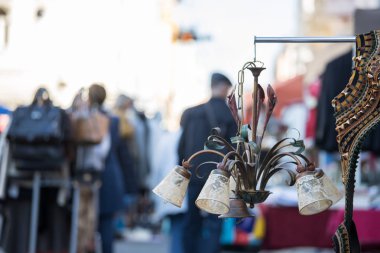 Flea market: Old fashioned lamp in the foreground, people in the clipart