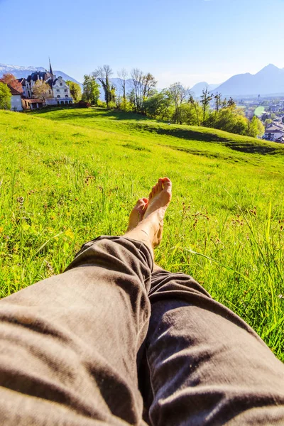 Chillen in het groene gras: benen van een jonge man, ontspannend, lachen — Stockfoto